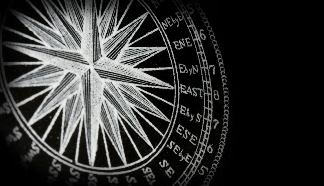 Ein alter weißer Kompass auf schwarzem Hintergrund