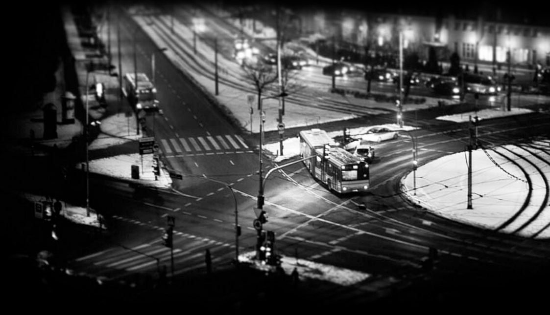 Eine Straßenkreuzung mit Autos und Bus bei Nacht
