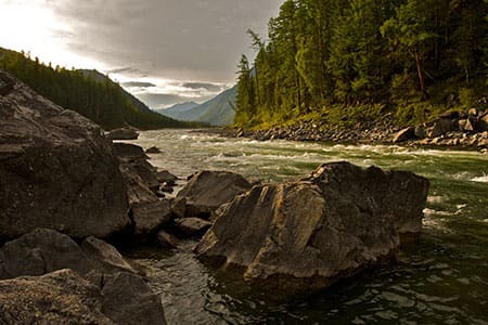 Referenz von delta4x4 Ein Tal mit Bäumen durch das ein Fluss fliest und Felsen zu sehen sind