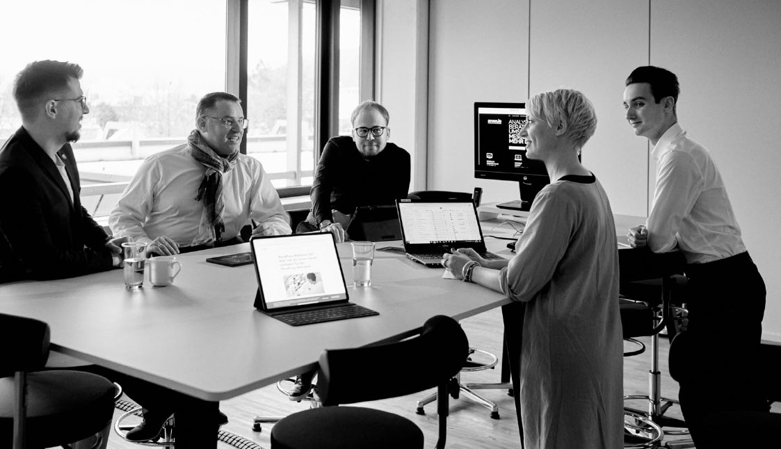 Strategische Analyse bei arven.io Das arvenio Team bespricht eine strategische Analyse eines Kunden an einem Stehtisch